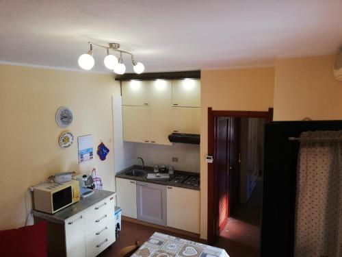 een keuken met een fornuis en een magnetron. bij Nico 12 in Santa Luria