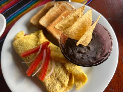a plate of food with chips and a bowl of dips at Hotel Nojoch che in Cobá