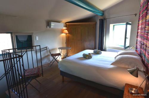 Les Maisons Mado في فيناسك: غرفة نوم بسرير كبير وبلكونة