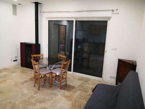 een eetkamer met een tafel en 2 stoelen bij Appartement entier dans dépendance in Saint-Morillon