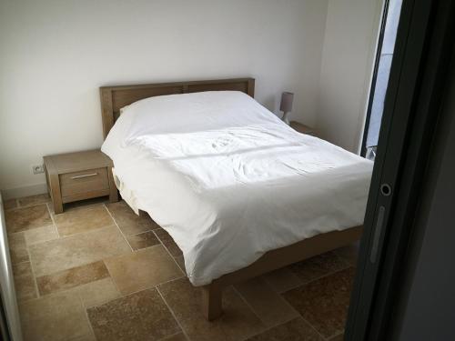 - une chambre dotée d'un lit avec des draps blancs dans l'établissement Appartement entier dans dépendance, à Saint-Morillon