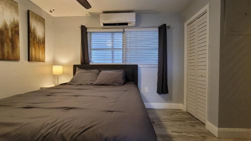 a bedroom with a large bed with a window at BEACHWAY INN in Lantana