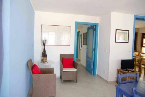 een woonkamer met rode kussens en een blauwe deur bij Casa delle Palme sulla spiaggia in Marzamemi