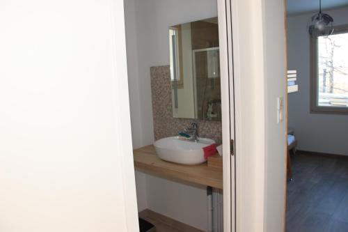 La salle de bains est pourvue d'un lavabo et d'un miroir. dans l'établissement ANCELLE TAILLAS RDC CHALET, à Ancelle