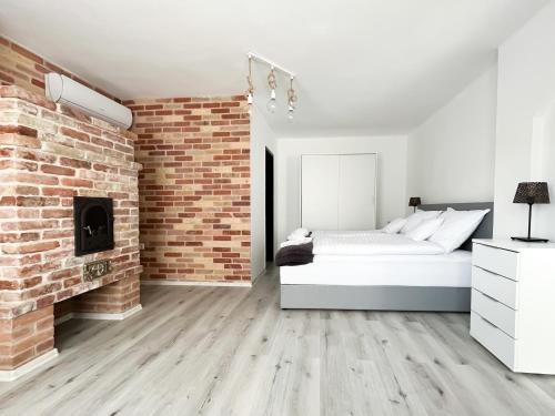 um quarto com uma parede de tijolos e uma cama em Ligeti Bástya Vendégház 
