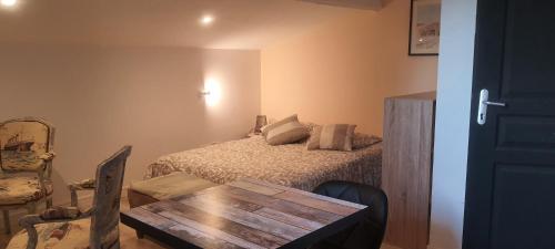- une chambre avec un lit et une table en bois dans l'établissement Chez Franck, à Saint-Martin-de-Valgalgues