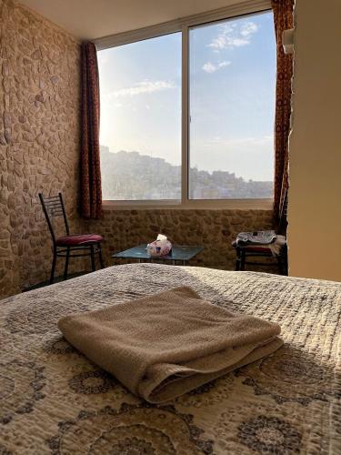 a bedroom with a bed with a large window at Orient Gate in Wadi Musa