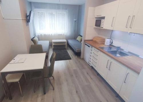 a small kitchen with a table and a dining room at Alisa Apartments in Kostomlaty