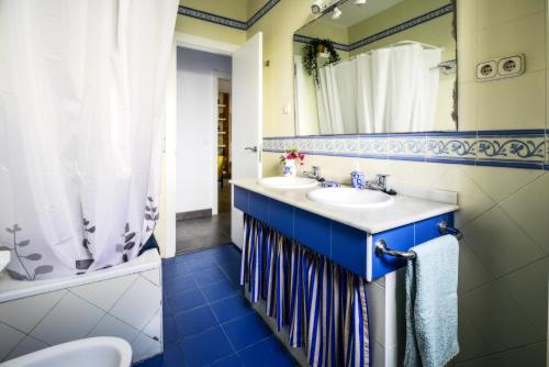 łazienka z dwiema umywalkami i lustrem w obiekcie AguaMarina w mieście Benajarafe