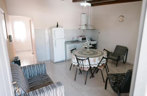 een keuken met een tafel en stoelen en een witte koelkast bij Departamento San Rafael in San Rafael