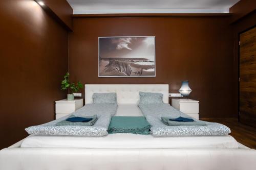 a bedroom with a large white bed with blue pillows at Nightingale Luxury Apartment in Budapest