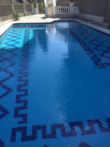 a large swimming pool with blue water at Condo in a Private Resort setting King Maryout Alamriyah Governorate Egypt Comes with an outdoor private infinity swimming pool with a large garden Borg Alarb International Airport is 15 minutes- Families Only in Alexandria