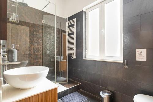 a bathroom with a sink and a glass shower at Guest House Bairro Azul in Lisbon