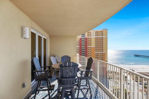a balcony with chairs and a table and the ocean at Oceanview 3BR Near Pier Park, Pool and Hot Tub in Panama City Beach