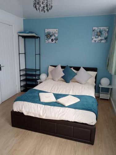 a bedroom with a large bed with blue walls at 1 bedroom flat in Luton free parking in Luton