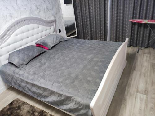 Квартира однокомнатная VIP في أورالسك: غرفة نوم بسرير مع اطار سرير ابيض