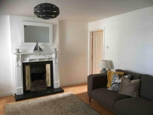 uma sala de estar com um sofá e uma lareira em Harbour View House em Ballycastle