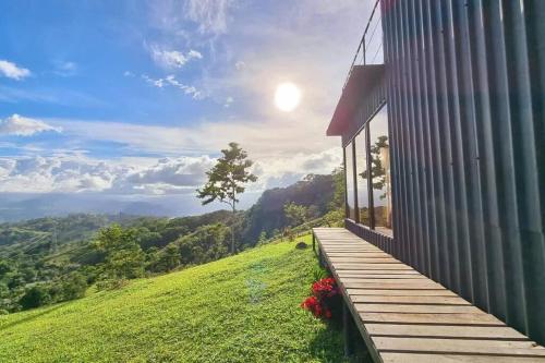 ein Haus auf einem Hügel mit einer Holzveranda in der Unterkunft Alto Luciérnaga 