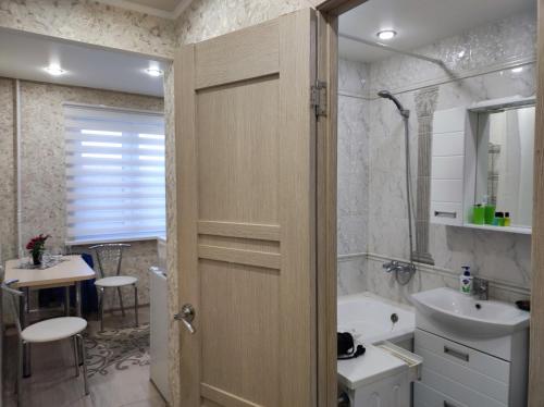y baño con ducha, aseo y lavamanos. en Домашний уют в центре, en Uralsk