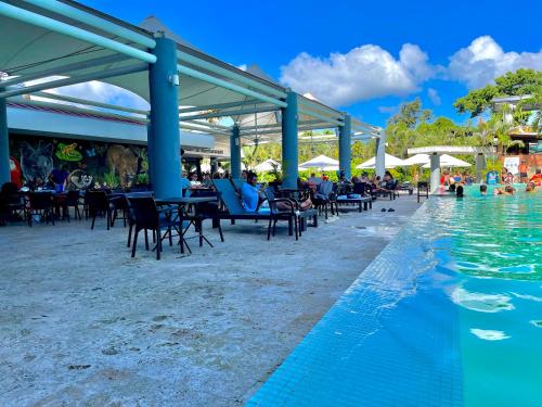 een zwembad in een resort met stoelen en mensen die zwemmen bij Summit Rainforest Golf Resort & All Inclusive in Paraíso
