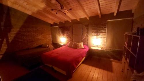 a bedroom with a red bed in a room at La Ñata in Villa Giardino