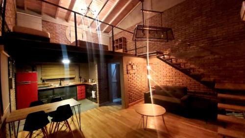 a living room with a staircase and a table and chairs at La Ñata in Villa Giardino