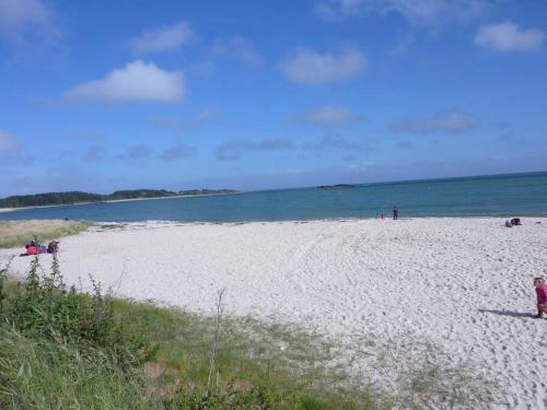 uma praia com pessoas na areia e na água em Maison 3 chambres 250 m de la mer em La Trinité-sur-Mer