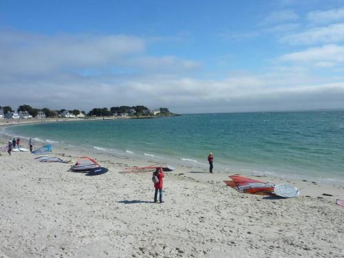 Un groupe de personnes debout sur une plage avec des cerfs-volants dans l'établissement Maison 3 chambres 250 m de la mer, à La Trinité-sur-Mer