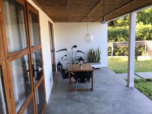 un patio con mesa de madera y sillas en Casa Bali Tofo en Praia do Tofo