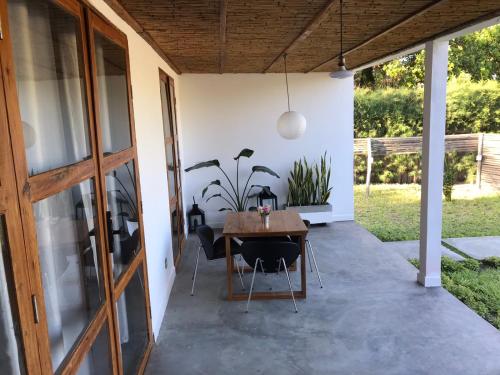a patio with a wooden table and chairs at Casa Bali Tofo in Praia do Tofo