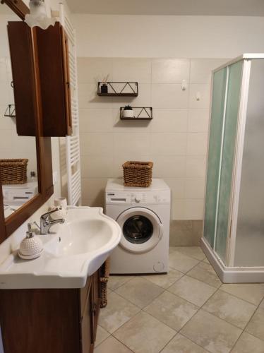 a bathroom with a washing machine and a sink at Trullo Nonna Rosa in Antonelli