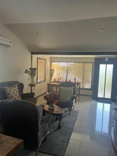 a living room with couches chairs and a table at THE TREE HOUSE in Grabouw