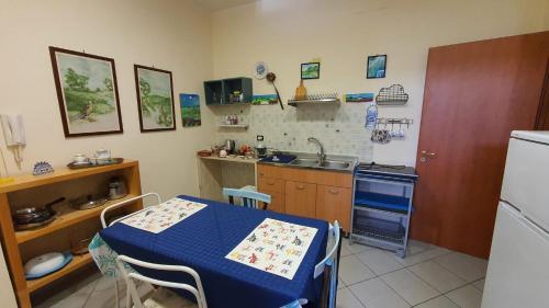 una cucina con tavolo, lavandino e frigorifero di Locazione Turistica Conca d'Oro a Crispiano