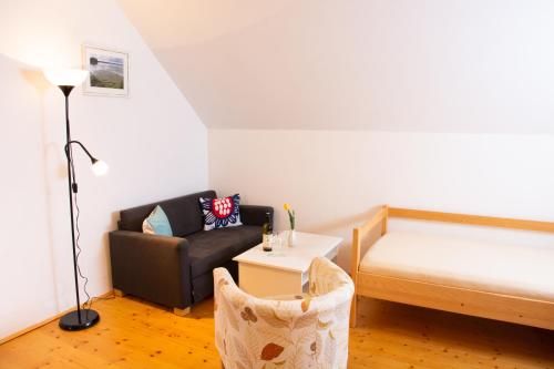 a small room with a bed and a couch at Penzion U hájovny u pískoven - Vlkov in Vlkov