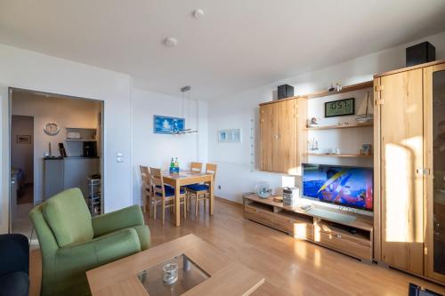a living room with a television and a dining room at Nordland Appartements - Wohnung Amrum in Wyk auf Föhr
