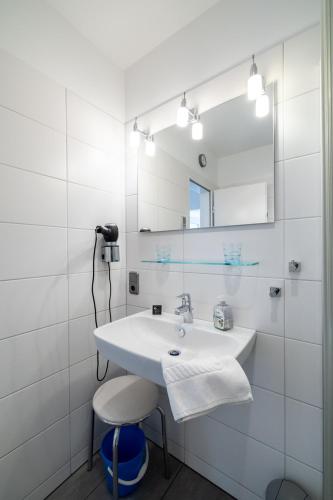 a bathroom with a sink and a mirror and a stool at Nordland Appartements - Wohnung Amrum in Wyk auf Föhr