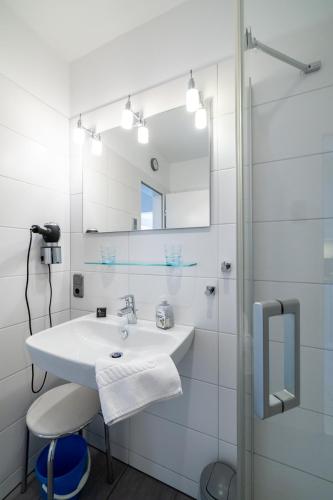 a white bathroom with a sink and a mirror at Nordland Appartements - Wohnung Amrum in Wyk auf Föhr