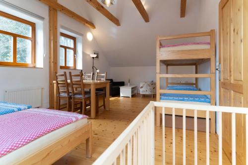 a room with a bed and a desk and bunk beds at Penzion U hájovny u pískoven - Vlkov in Vlkov