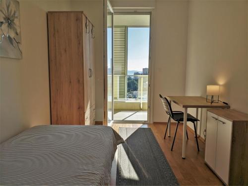 um quarto com uma cama, uma secretária e uma mesa em Izzy&Simple em Split