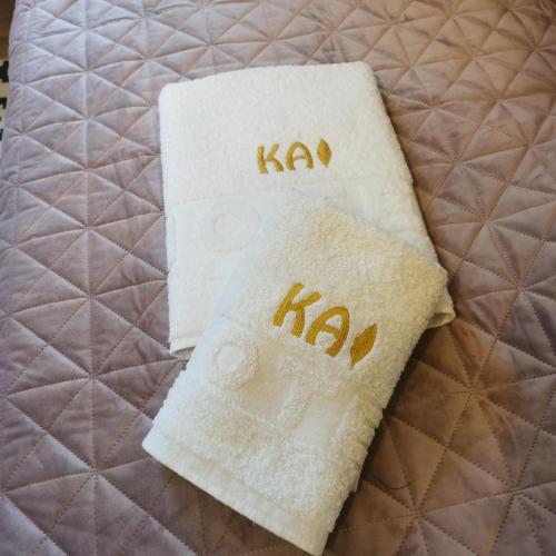 two towels with the word kaan on a bed at Kai Apartman in Kopaonik