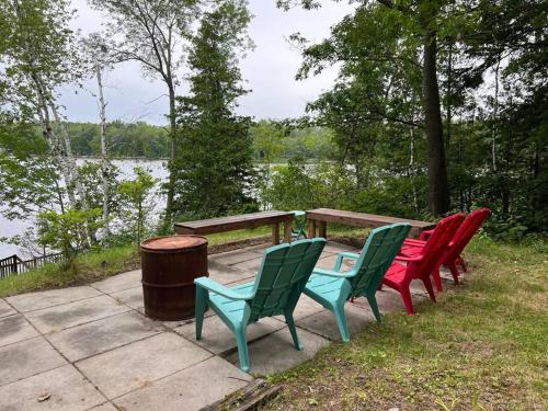 um grupo de cadeiras em torno de uma mesa de piquenique ao lado de um lago em Marmora Hideaway - Lake front em Marmora