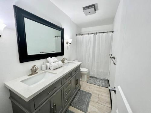 a bathroom with a sink and a mirror and a shower at NEW! Remodeled Stow/Cuyahoga Falls Home! in Stow