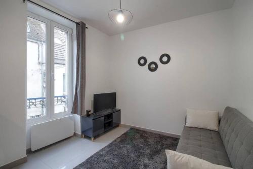 un salon avec un canapé et une télévision dans l'établissement Appartement centre-ville, à Lagny-sur-Marne