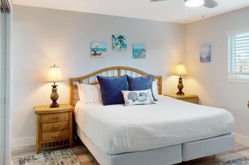 a bedroom with a bed with blue pillows and two lamps at Chateau La Mer 2A in Destin