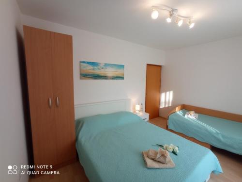 Apartment Milotić في لوفران: غرفة نوم بسريرين مع ملايات زرقاء وورود