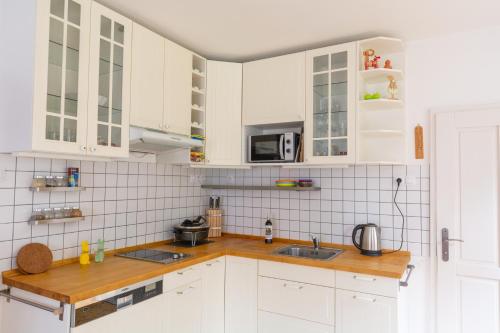 a white kitchen with white cabinets and a sink at Penzion U hájovny u pískoven - Vlkov in Vlkov