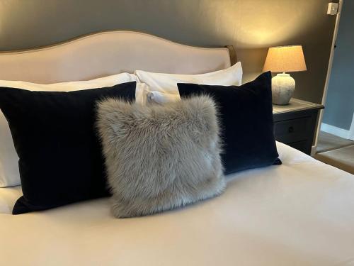 a furry pillow sitting on top of a bed at Meadow Cottage in Salisbury