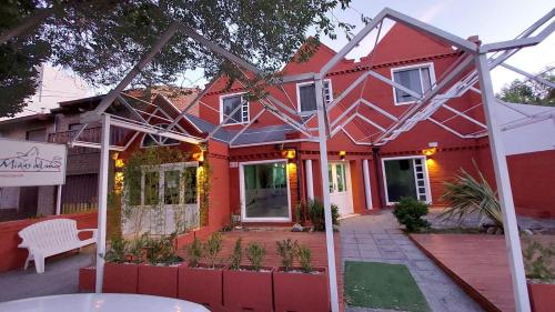 ein rotes Haus mit weißem Dach in der Unterkunft Miras Del Mar in Puerto Madryn