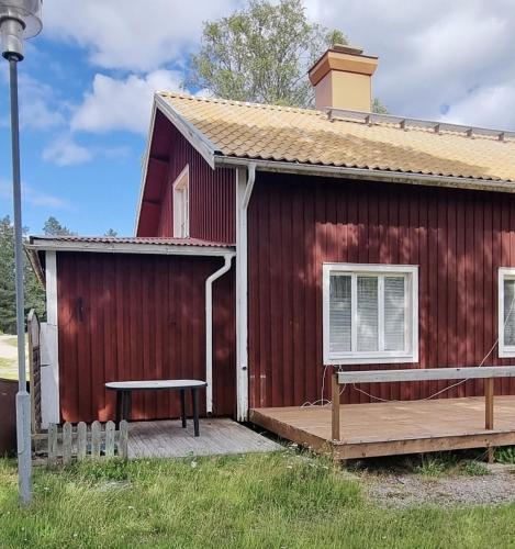 una casa roja con un banco delante en Mysig Lägenhet för resande., en Stocka