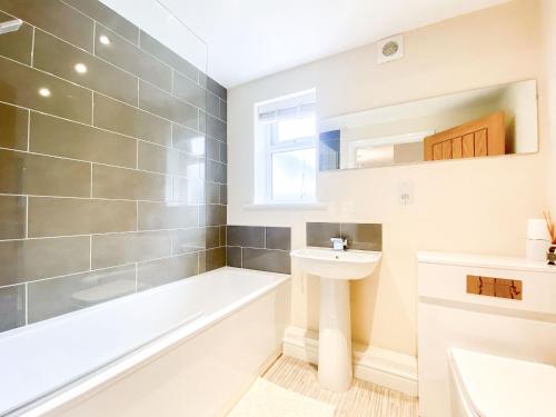 a bathroom with a bath tub and a sink at Peacock Court in Corsham